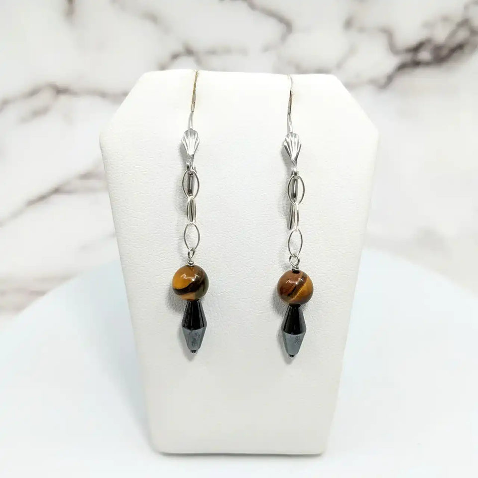 Silver dangle earrings featuring tiger’s eye beads and black crystal drops.