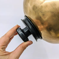 Hand holding brass Singing Bowl 3.2’ with black rubber suction handle #LV2901