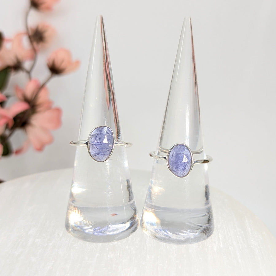 Two silver rings with lavender Tanzanite faceted stones in a product display