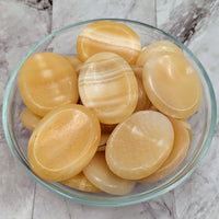 A bowl of sliced peeled potatoes next to a Yellow Aragonite Thumb Stone 2’ #LV2297