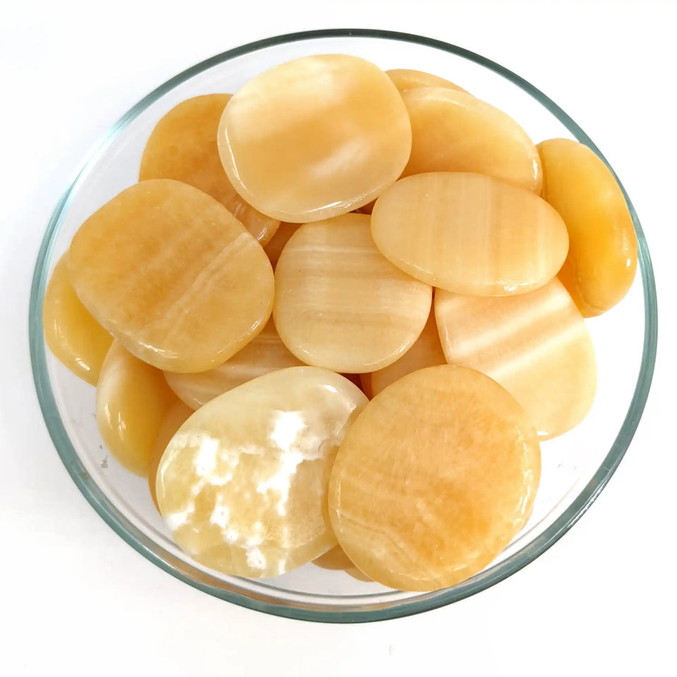 Yellow butterscotch candy discs in a clear glass bowl.