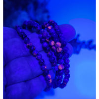 Purple Yooperlite UV-reactive 4mm beaded stretch bracelet with wooden beads